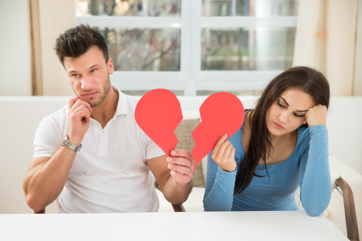 Unhappy couple holding broken heart